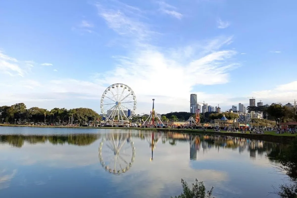 Parque Barigui — roda-gigante refletida no lago e skyline da cidade
